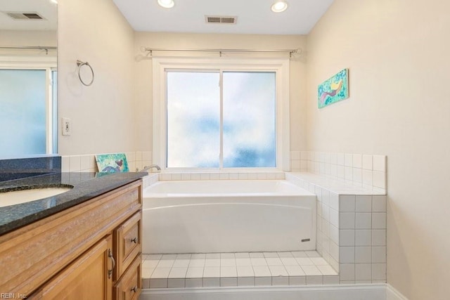 bathroom with a bath, visible vents, recessed lighting, and vanity