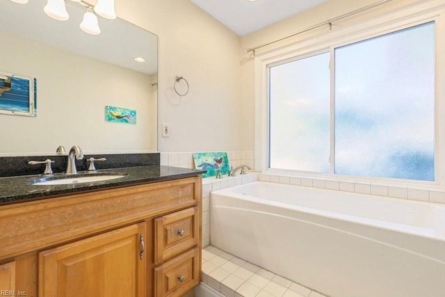 bathroom with a garden tub, vanity, and tile patterned flooring