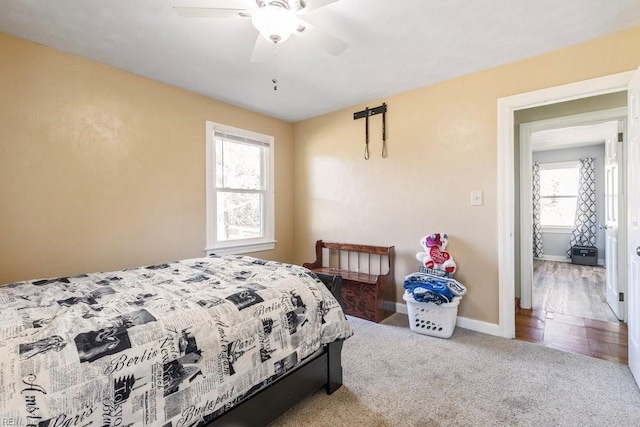 carpeted bedroom featuring baseboards and a ceiling fan