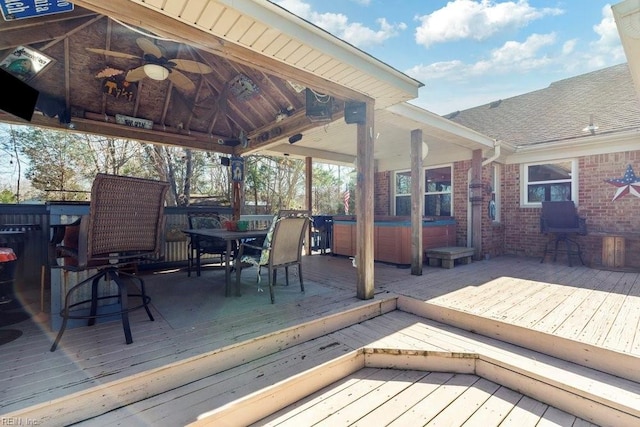 wooden deck with a gazebo, outdoor dining space, a hot tub, and a ceiling fan