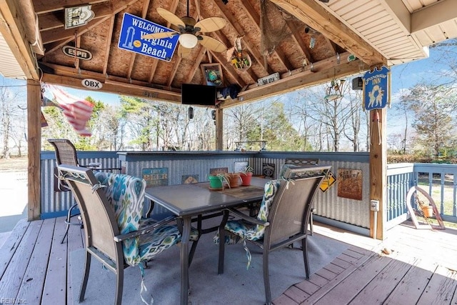 wooden terrace with a gazebo and outdoor dining area