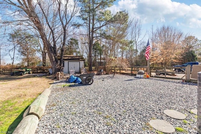 view of yard with a storage shed, an outdoor structure, and fence