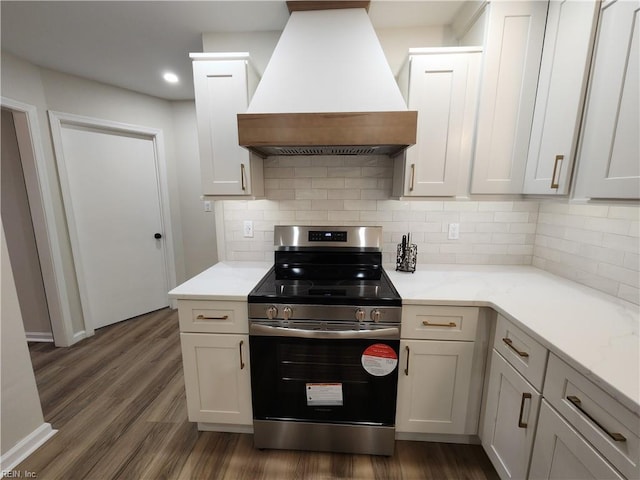 kitchen with decorative backsplash, stainless steel electric stove, premium range hood, and dark wood-style flooring