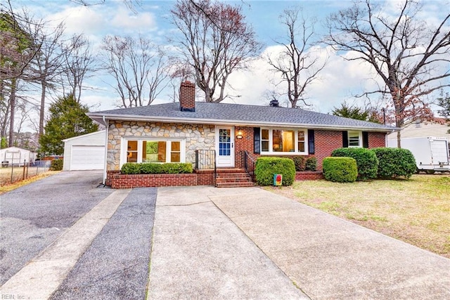 single story home with an outbuilding, stone siding, a front yard, a garage, and a chimney