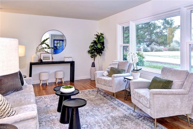 living room with visible vents, baseboards, and wood finished floors