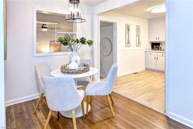 dining room featuring wood finished floors and baseboards