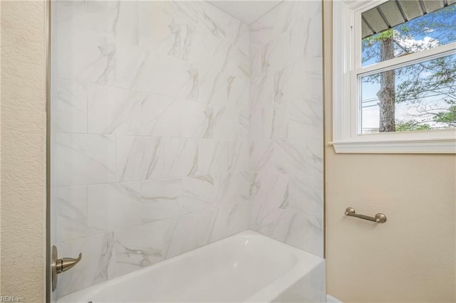 full bathroom with bathing tub / shower combination and a textured wall