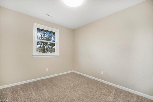 carpeted spare room featuring baseboards and visible vents