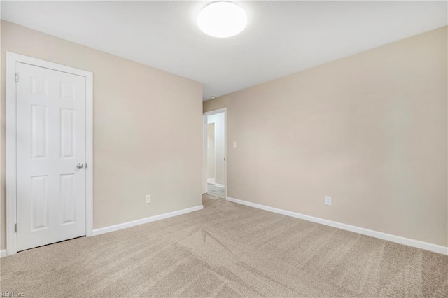 spare room with baseboards and carpet flooring