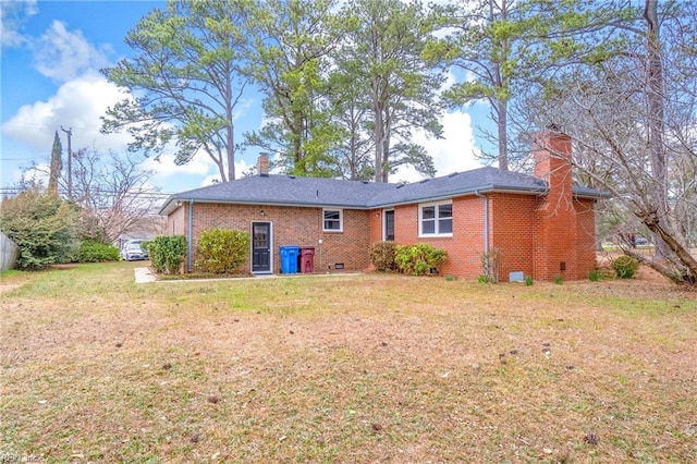 back of property featuring brick siding, a chimney, and a lawn