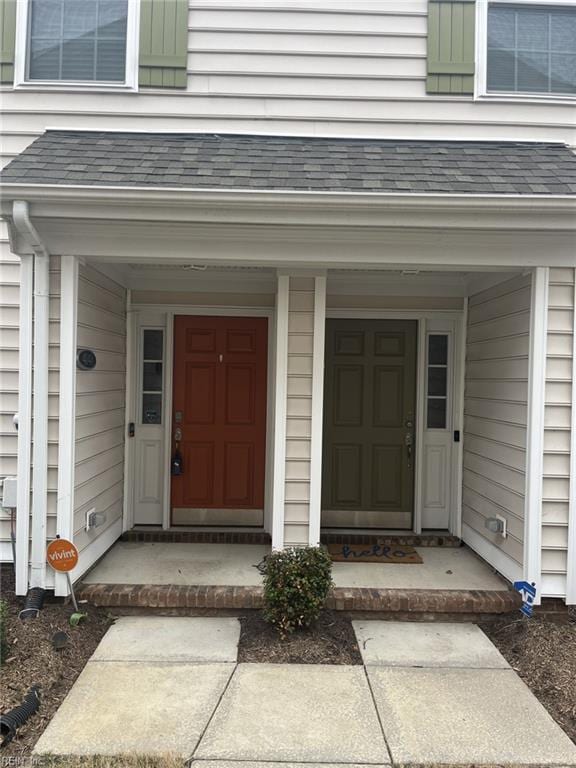 entrance to property featuring a shingled roof