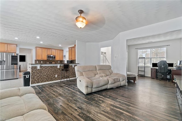 living area with recessed lighting and wood finished floors