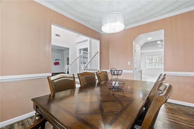 dining area featuring ornamental molding, wood finished floors, stairway, an inviting chandelier, and baseboards