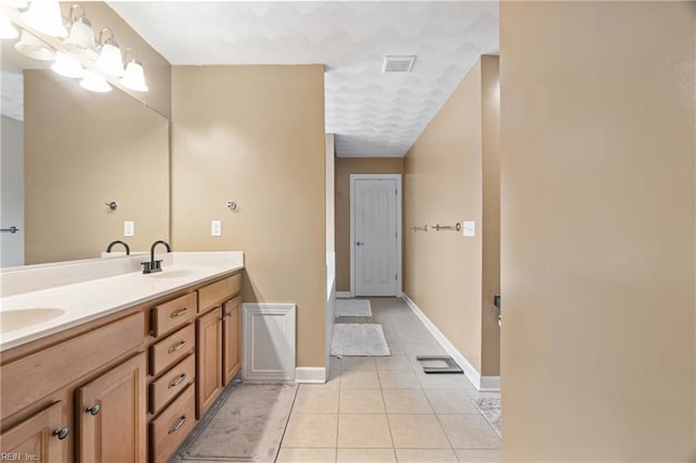 full bath with tile patterned floors, visible vents, a sink, double vanity, and baseboards