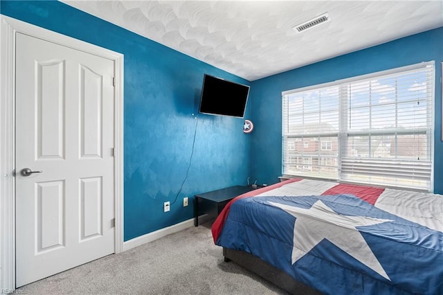 bedroom with visible vents, baseboards, and carpet