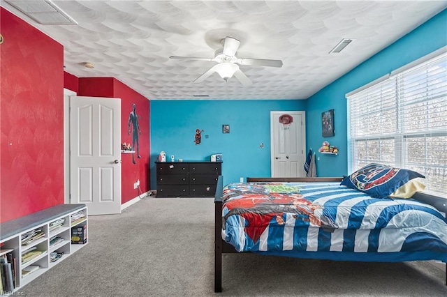 carpeted bedroom featuring visible vents, baseboards, and ceiling fan