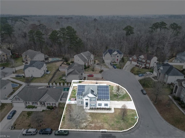 drone / aerial view featuring a residential view and a wooded view