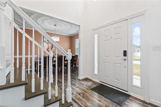 foyer featuring a wealth of natural light, baseboards, dark wood-type flooring, and stairs