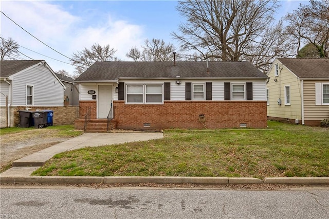 view of front of property featuring crawl space, brick siding, a front lawn, and a shingled roof