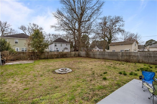 view of yard with a patio area, a fenced backyard, a residential view, and an outdoor fire pit