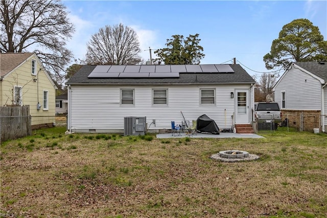 back of property featuring roof mounted solar panels, a lawn, and a fenced backyard