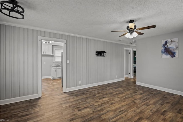 unfurnished room with crown molding, baseboards, ceiling fan, dark wood finished floors, and a textured ceiling