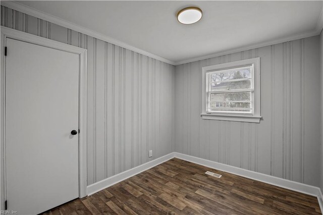 unfurnished room featuring visible vents, baseboards, and dark wood-style floors