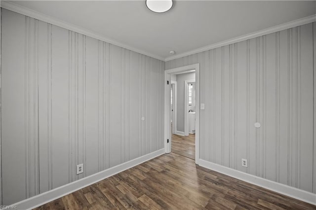 unfurnished room with baseboards, dark wood-style floors, and ornamental molding