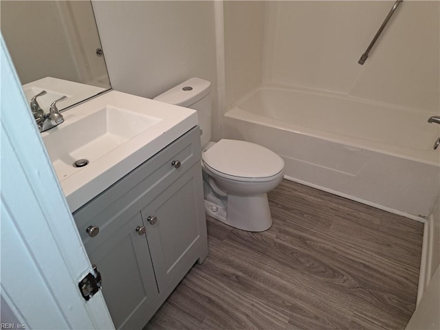 bathroom featuring shower / bath combination, toilet, vanity, and wood finished floors