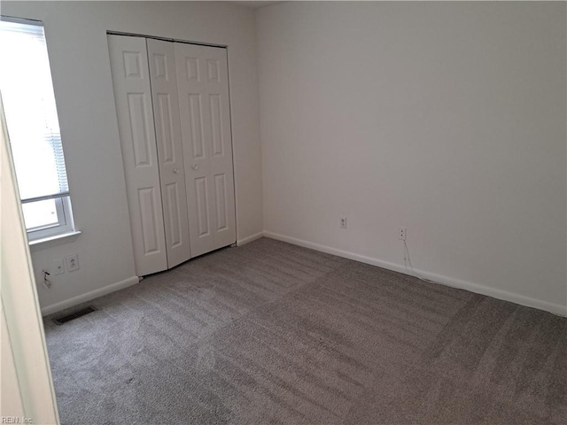 unfurnished bedroom with a closet, baseboards, and carpet floors