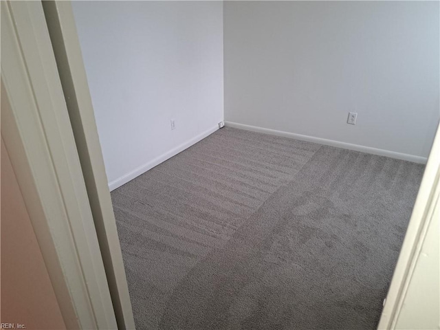 carpeted spare room featuring baseboards