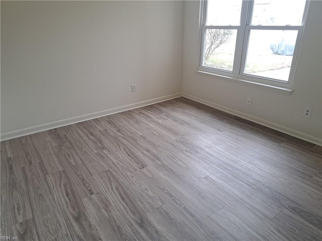 unfurnished room with baseboards and wood finished floors