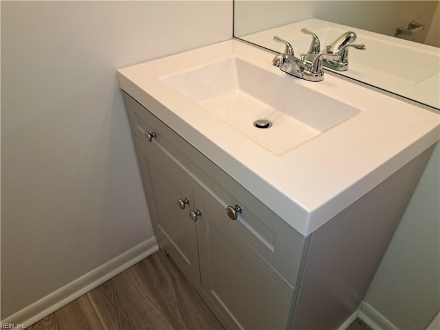 bathroom featuring baseboards, wood finished floors, and vanity