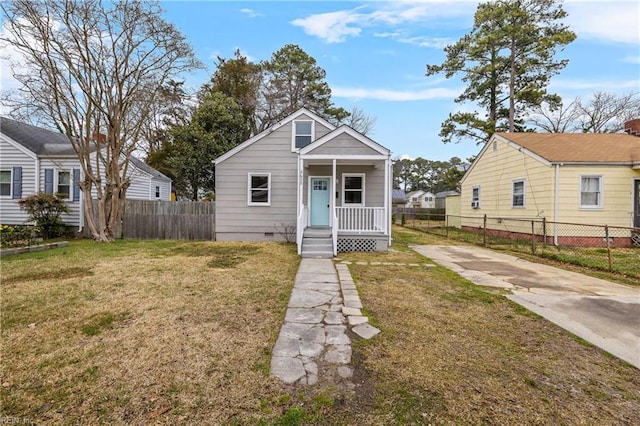 bungalow-style home with crawl space, covered porch, a front yard, and fence