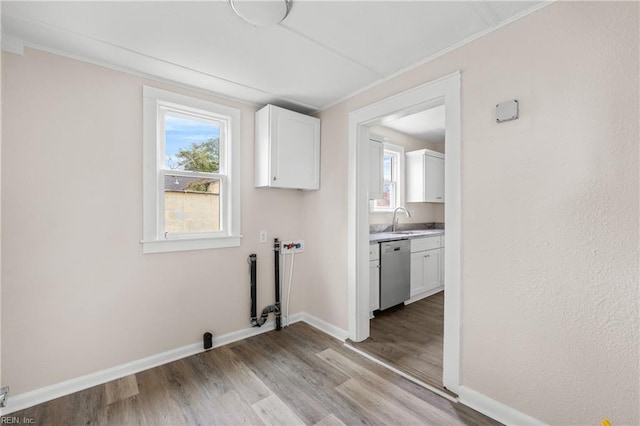 clothes washing area with light wood-style flooring, a sink, cabinet space, baseboards, and hookup for a washing machine