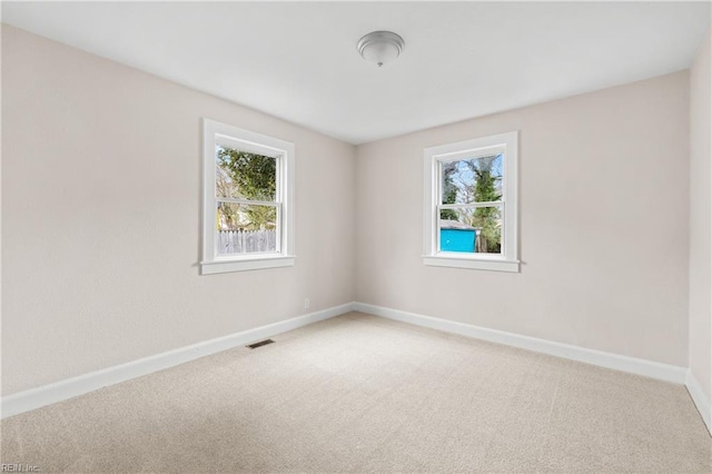 carpeted empty room with visible vents and baseboards