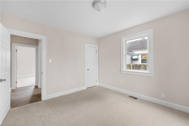 spare room with baseboards, visible vents, and carpet floors