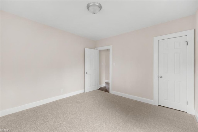 unfurnished bedroom featuring carpet flooring and baseboards