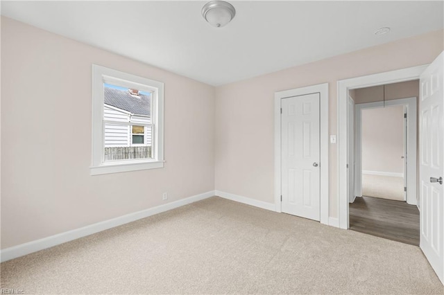 carpeted empty room featuring baseboards