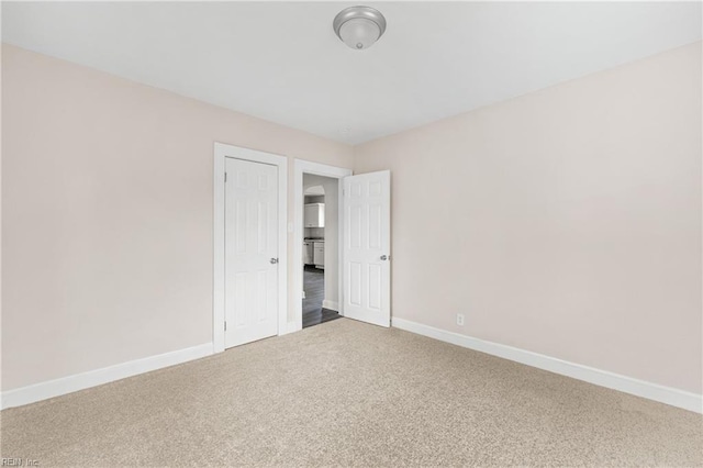 spare room featuring carpet flooring and baseboards