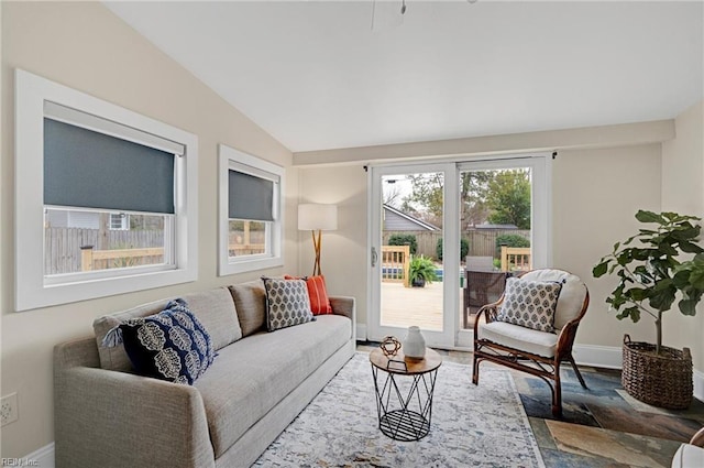 living room featuring baseboards and lofted ceiling