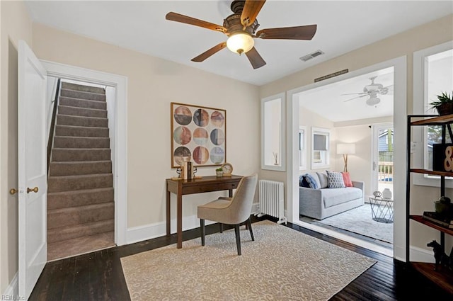 office space with ceiling fan, visible vents, wood finished floors, and radiator heating unit