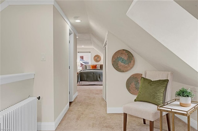 hallway featuring recessed lighting, radiator, baseboards, light colored carpet, and vaulted ceiling