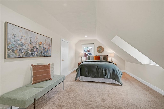 carpeted bedroom with vaulted ceiling with skylight and baseboards