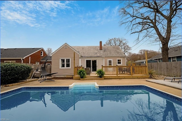 rear view of house with a fenced in pool, a patio, a wooden deck, and a fenced backyard