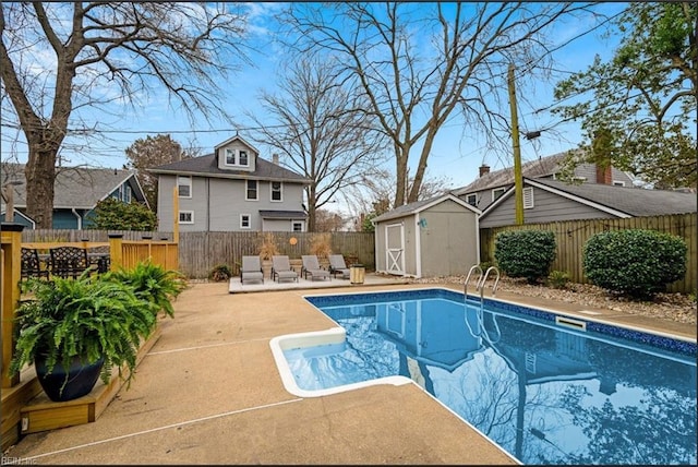 view of swimming pool with a fenced backyard, a storage shed, an outdoor structure, a fenced in pool, and a patio area