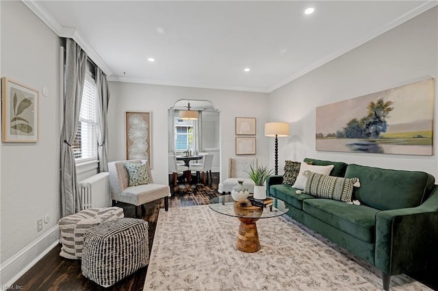 living area with wood finished floors, recessed lighting, arched walkways, crown molding, and baseboards