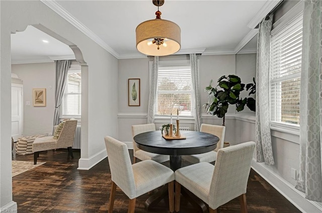 dining room featuring baseboards, wood finished floors, and ornamental molding