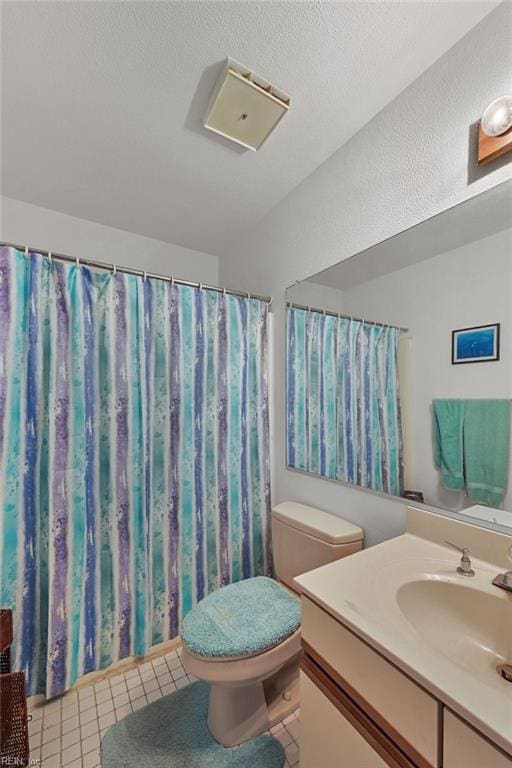 bathroom featuring tile patterned floors, toilet, vanity, and a textured ceiling