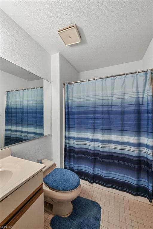 full bathroom featuring vanity, toilet, a shower with curtain, and a textured ceiling